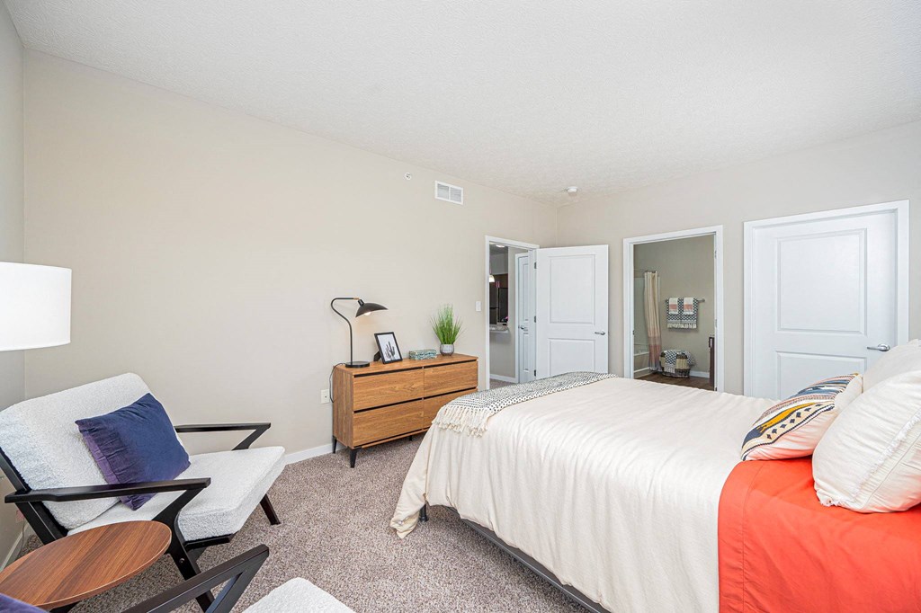 a bedroom with a bed and a chair and a closet