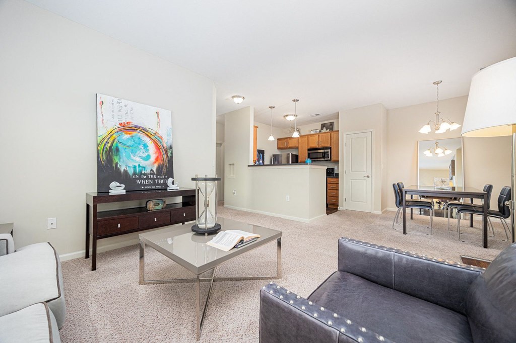 A living room with a grey couch and a glass coffee table.