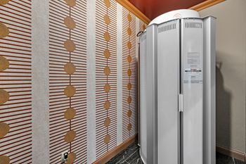 A wall with a brown and white patterned wallpaper and a white fridge.