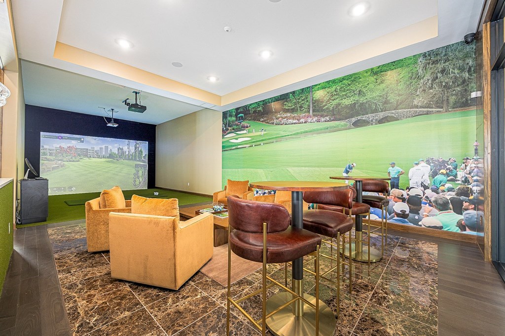 A room with a large screen and a bar area.