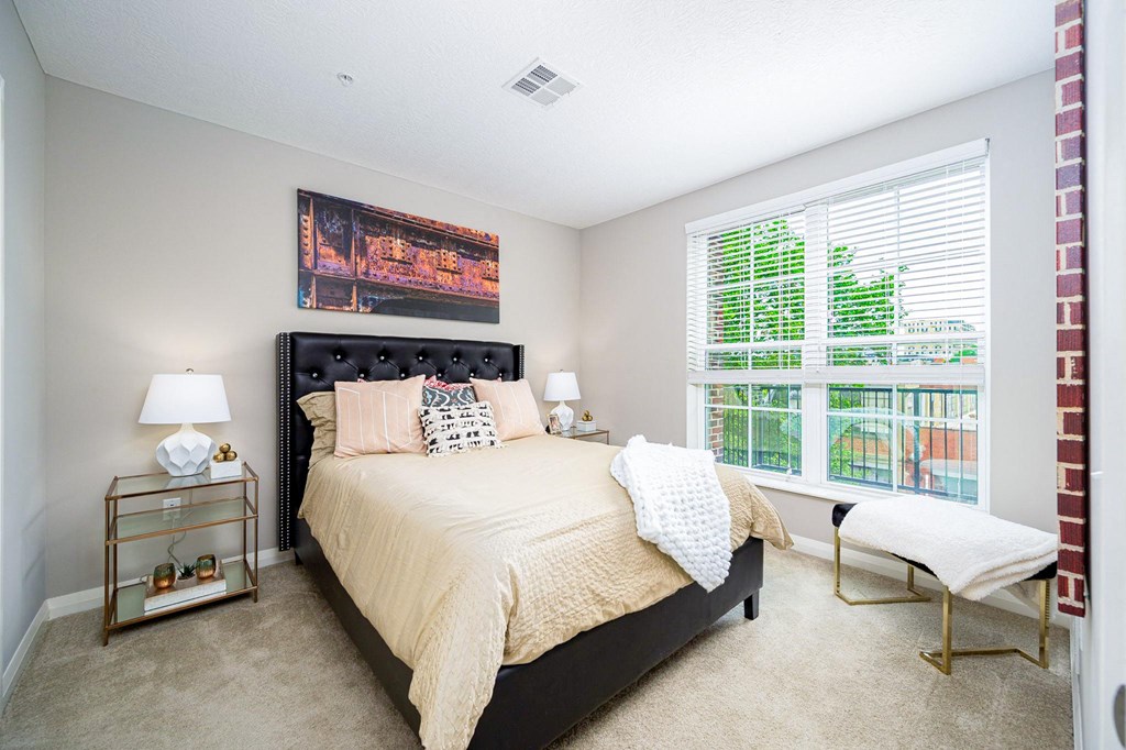 a bedroom with a bed and a large window