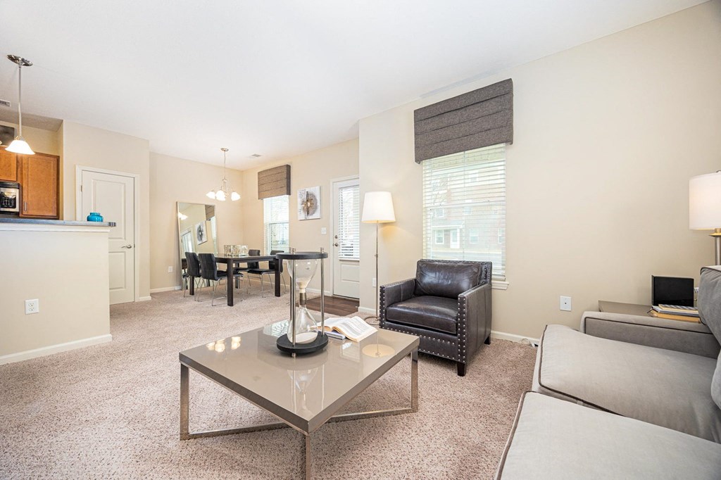 A living room with a glass coffee table in the center.