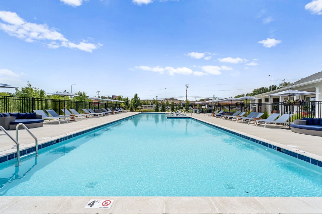 A large swimming pool with a blue water and a sign on the ground.