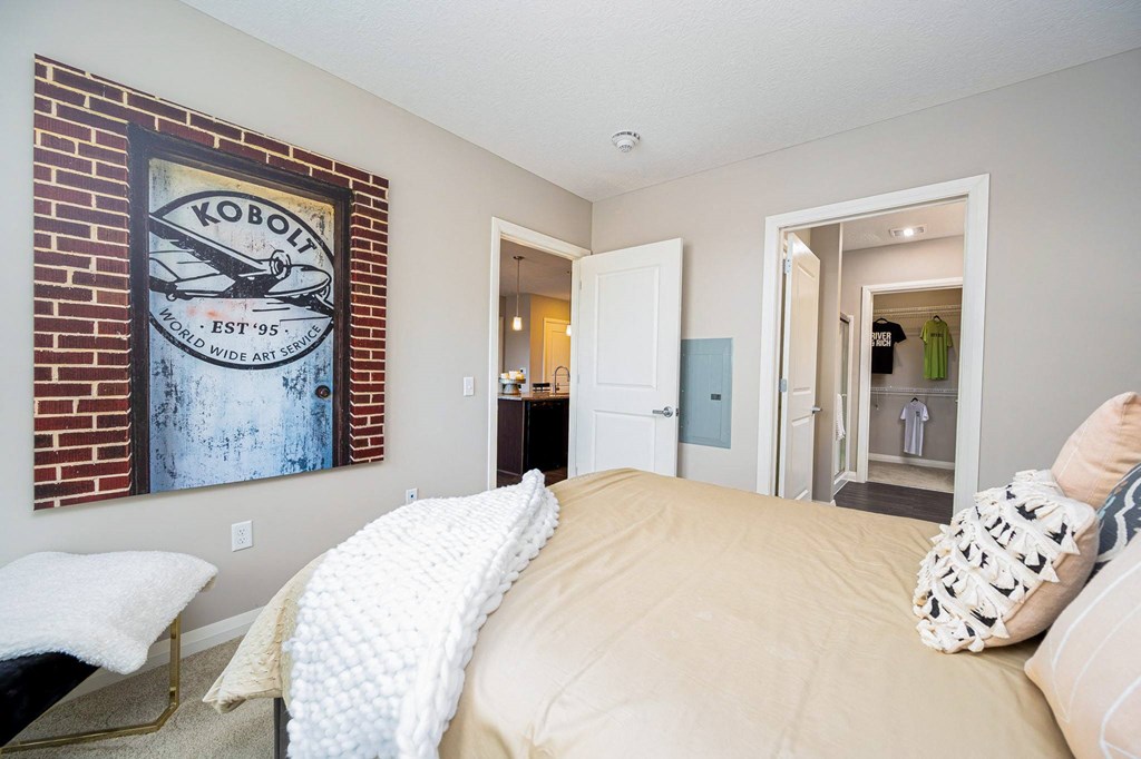 a bedroom with a bed and a painting on the wall