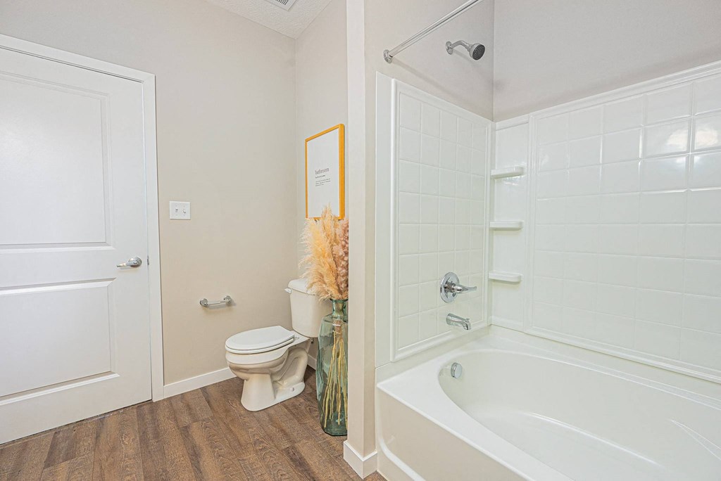 a bathroom with a shower and a toilet and a tub