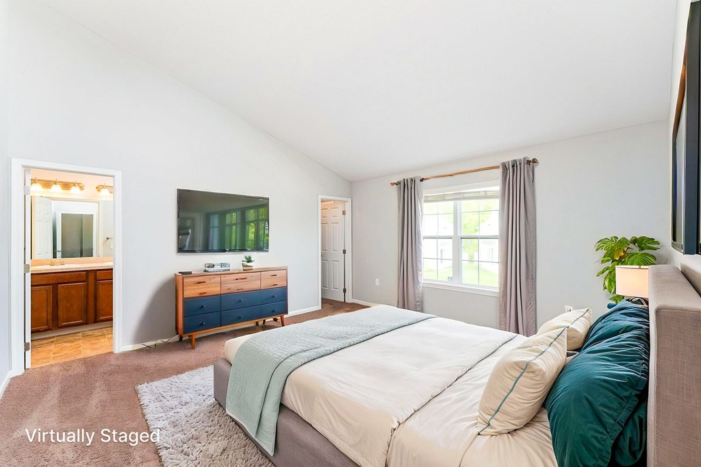 A bedroom with a bed, dresser, and window.