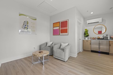 A living room with a grey couch, a coffee table, and a painting on the wall.