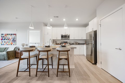 A kitchen with white cabinets and a white fridge.