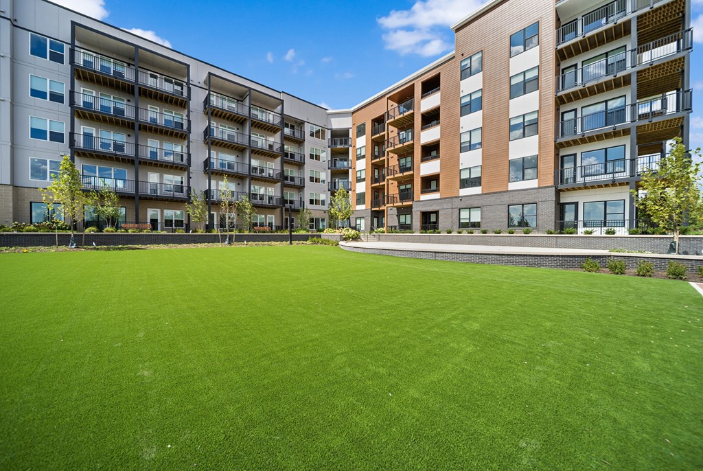 A large grassy area in front of apartment buildings.