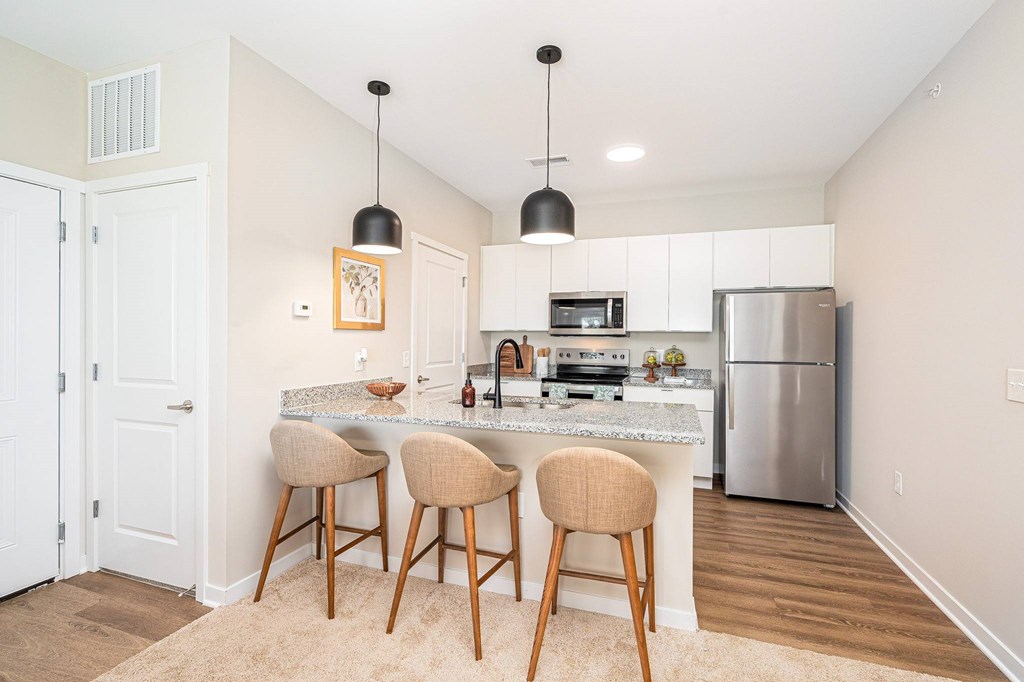 A kitchen with a bar and stools.