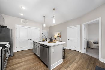 A kitchen with a refrigerator, sink, and cabinets.