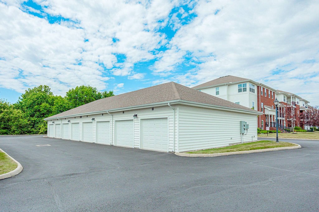 a garage with white doors and a building in the background