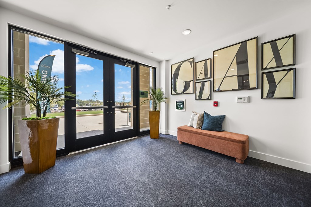 A room with a bench, a plant, and a wall with the word "GALLERY" on it.