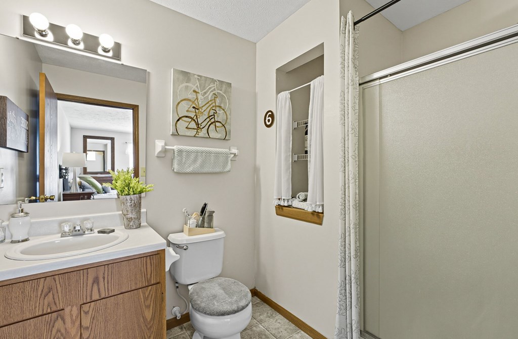 A bathroom with a toilet, sink, and mirror.