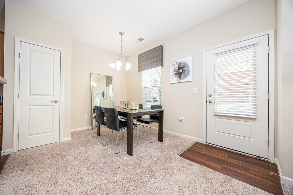 A room with a dining table and chairs.