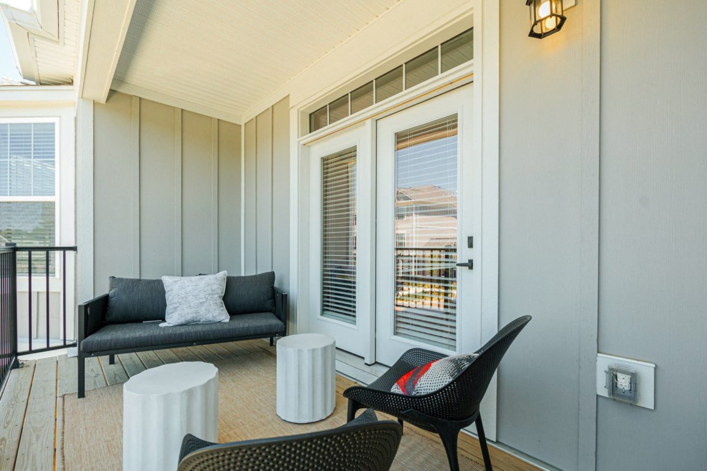 a living room with a couch and chairs and a balcony