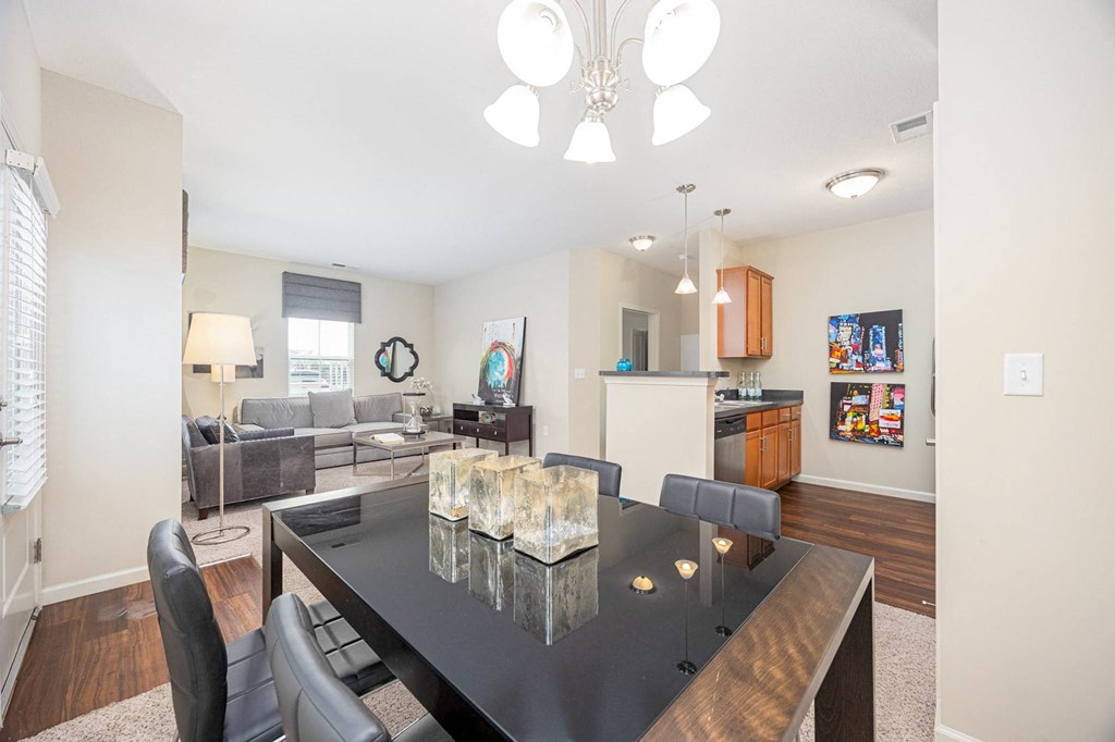 A modern dining room with a glass table and chairs.