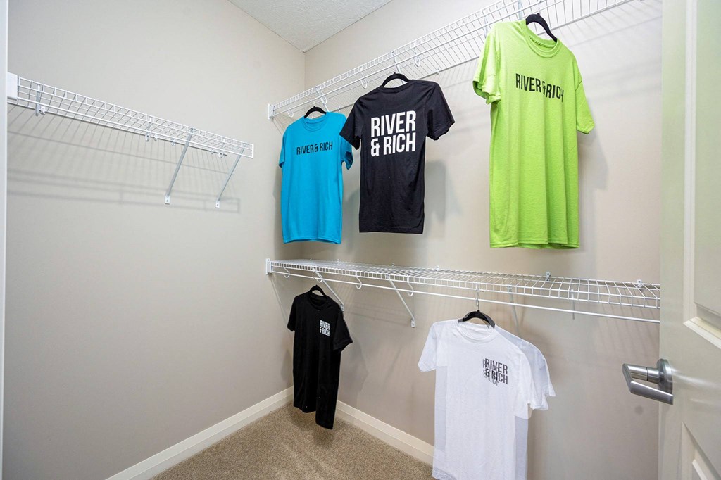 a laundry room with racks of t shirts on the wall