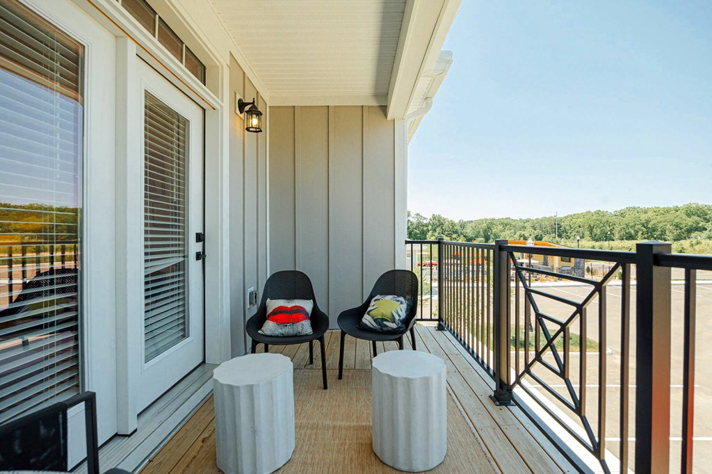 a balcony with two chairs and a view of a river
