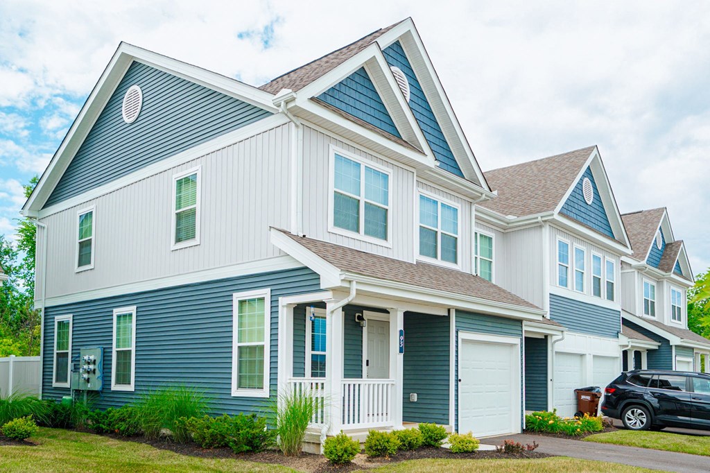 a blue and white house with a car parked in front of it