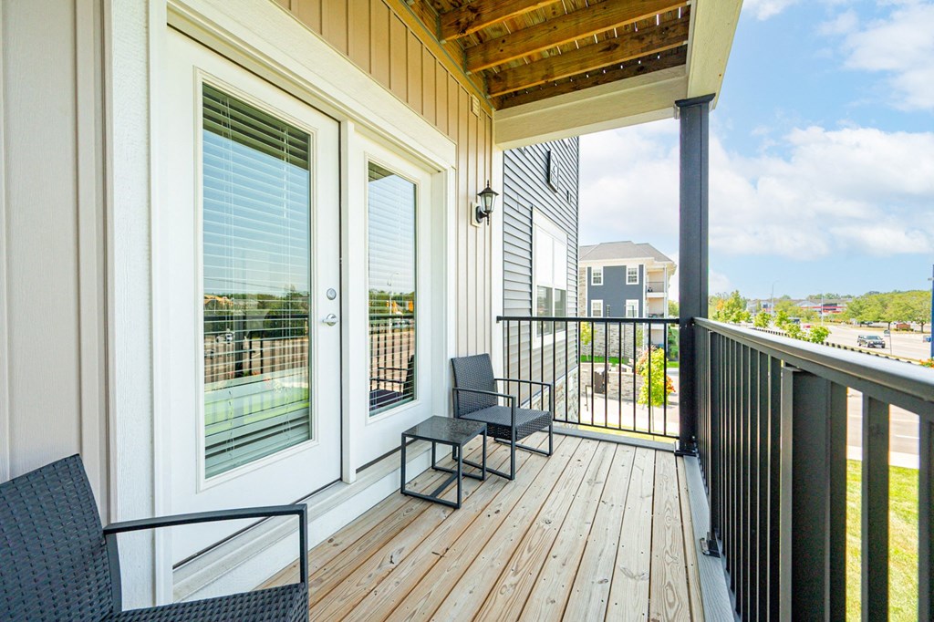 a balcony with two chairs and a wooden deck