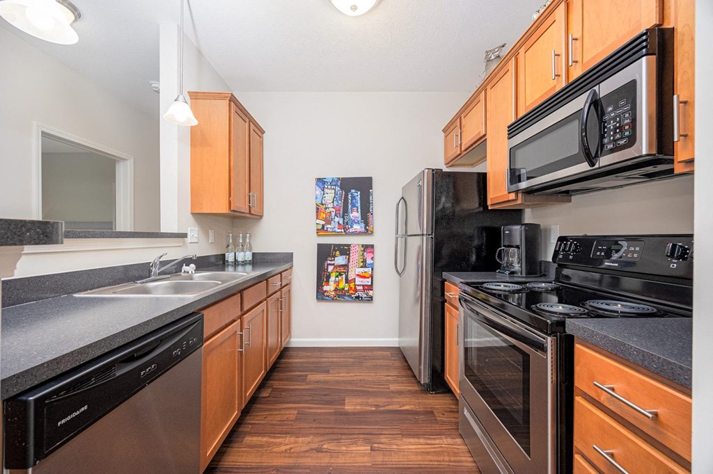A kitchen with black appliances and wooden cabinets.