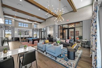 A modern living room with a dining area and kitchen in the background.