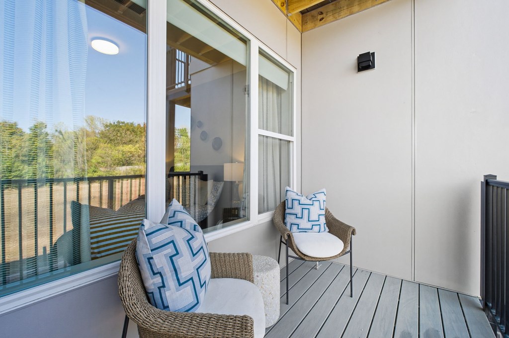 A balcony with a chair and a pillow.
