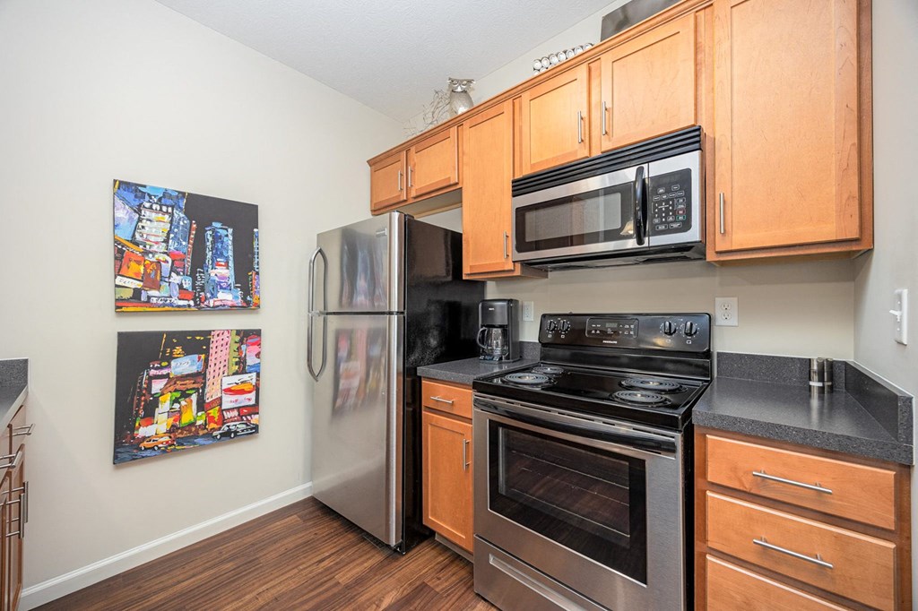 A kitchen with a stainless steel refrigerator, oven, and microwave.