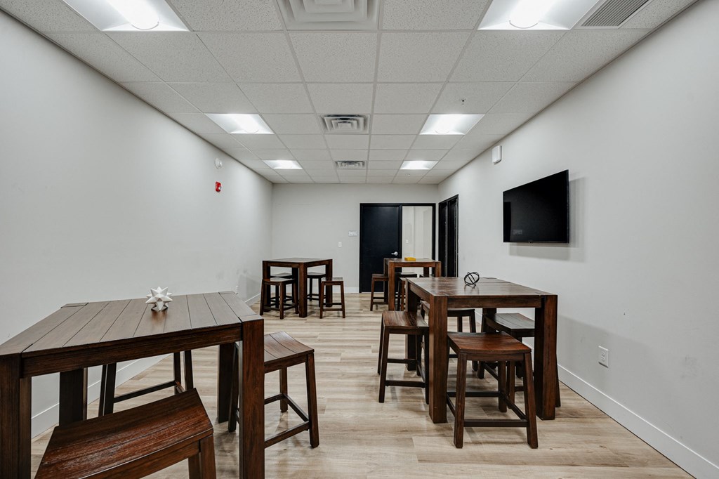 a dining room with tables and chairs and a tv