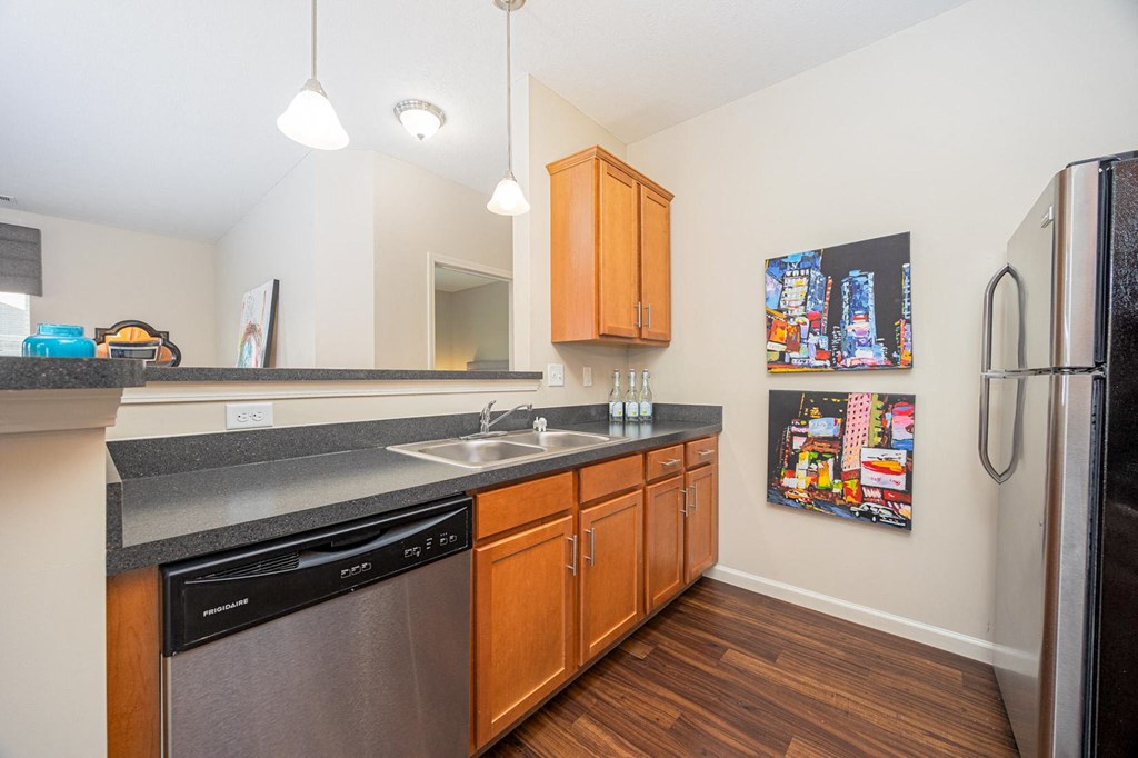 A kitchen with wooden cabinets and a black fridge.