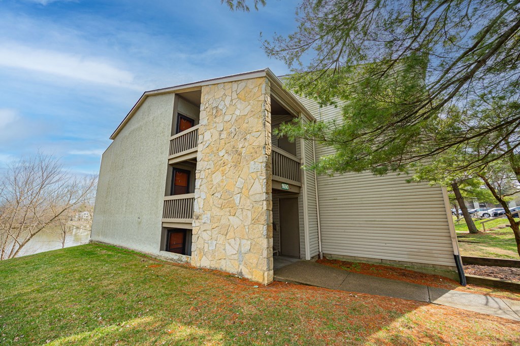 A house with a stone facade and a grey roof.