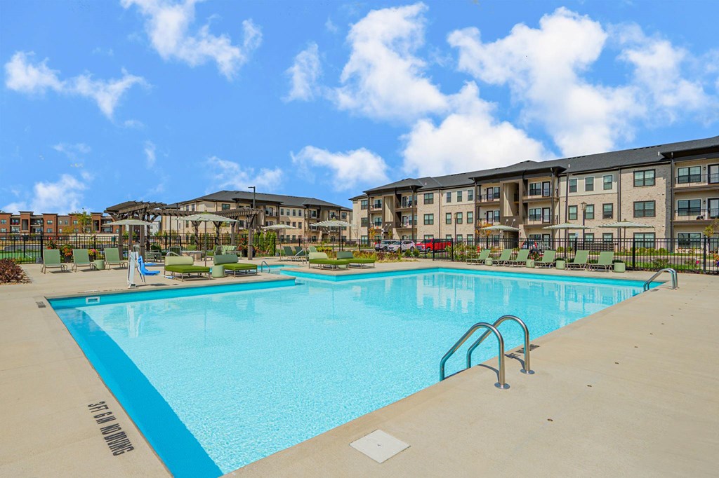 A large swimming pool in front of apartment buildings.