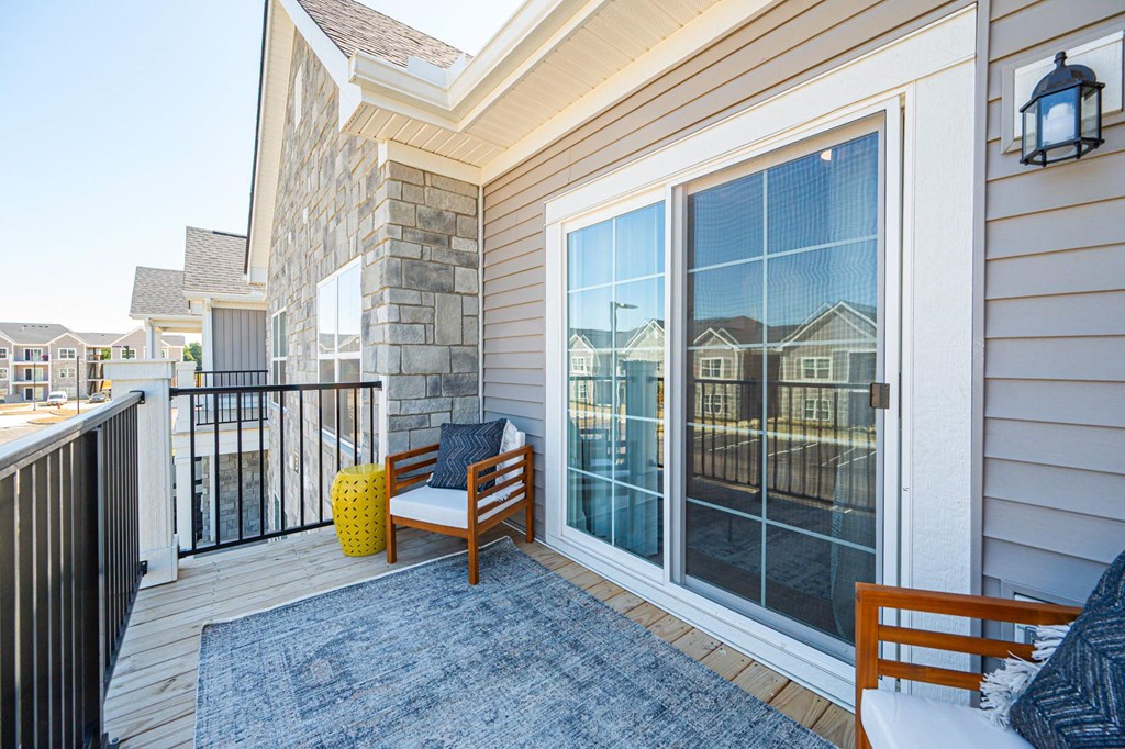 A balcony with a bench and a table with a yellow container on it.