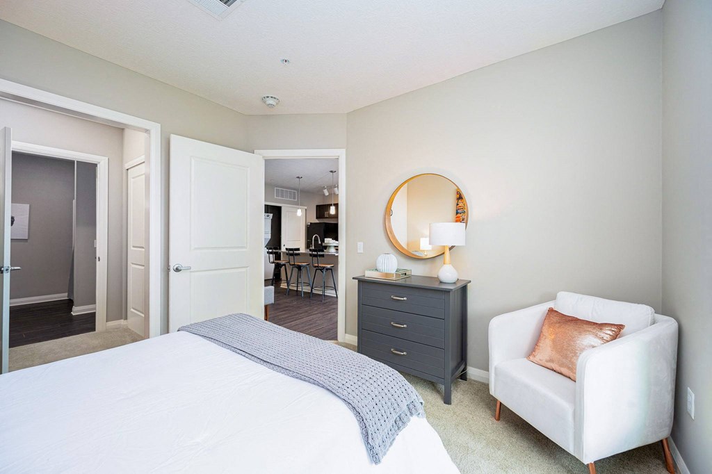 a bedroom with a white bed and a white chair