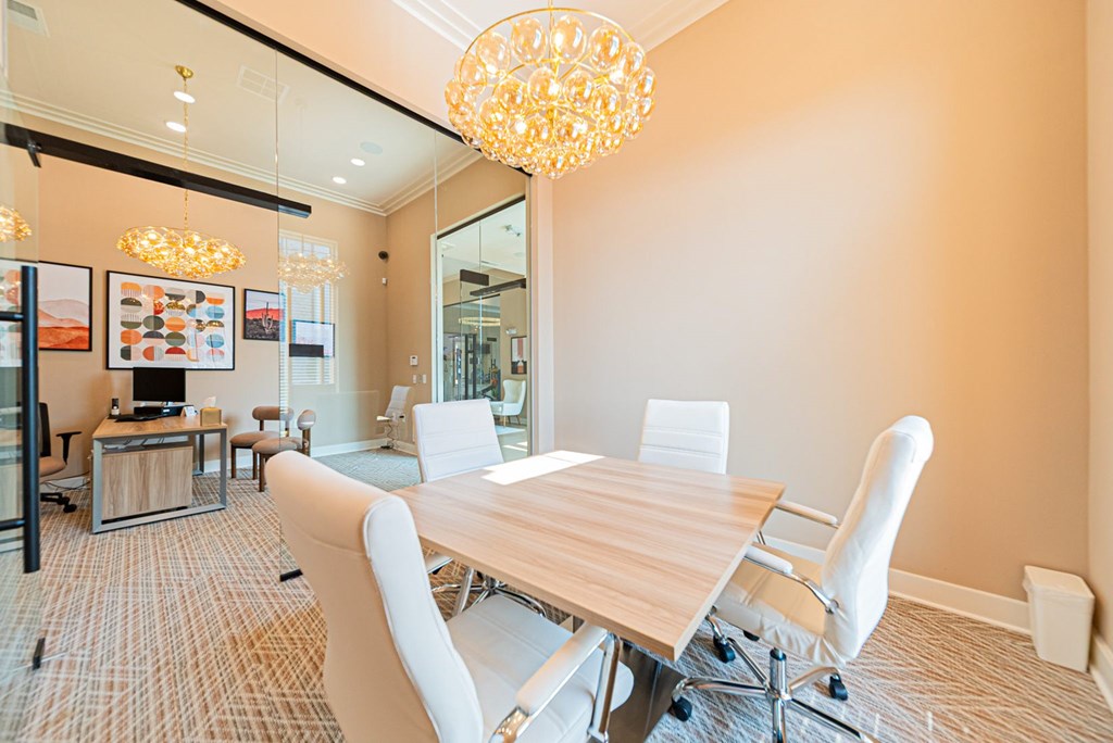 A conference room with a long table and chairs.