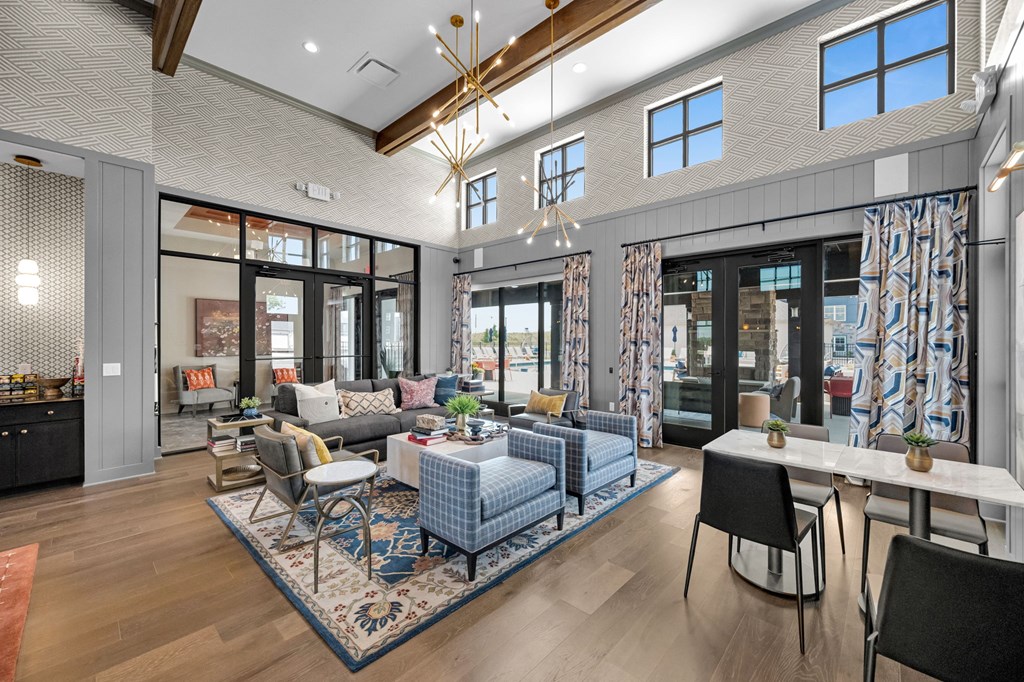 A modern living room with a blue rug and a dining table.