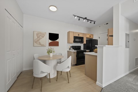 A modern kitchen with a dining table and chairs.