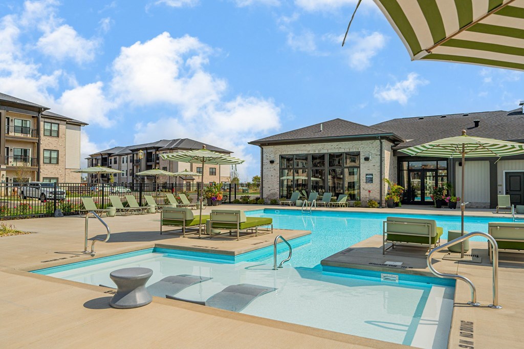A swimming pool with a sun lounger and umbrella.