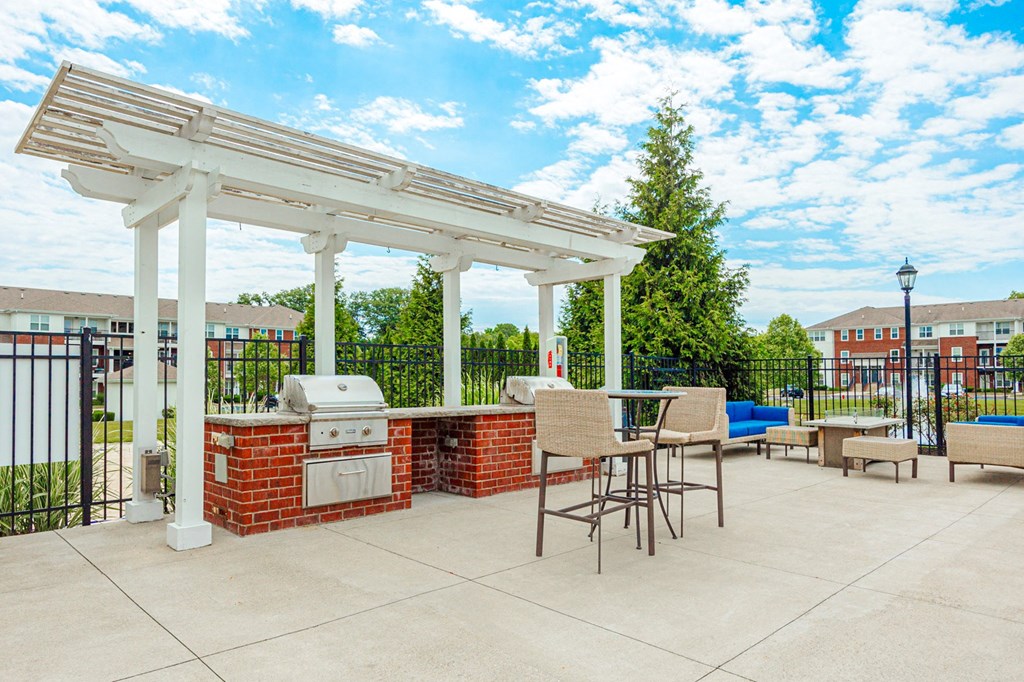 a patio with a barbecue grill and a pergola