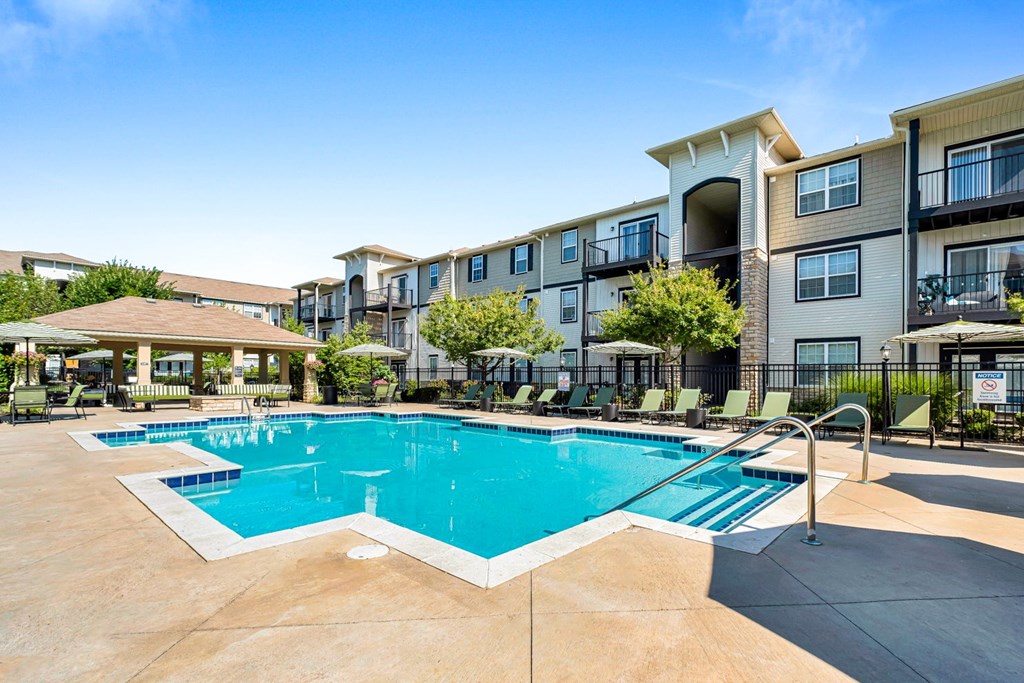 A large swimming pool in front of apartment buildings.