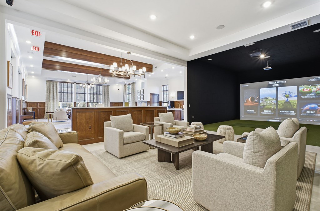 A living room with a brown couch and a chandelier.