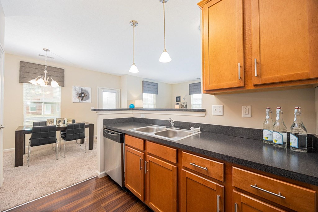 A kitchen with wooden cabinets and a black countertop.