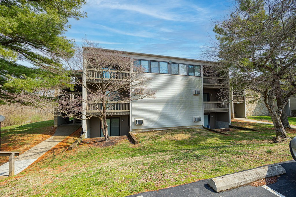 A modern two-story apartment building with a balcony on the second floor.