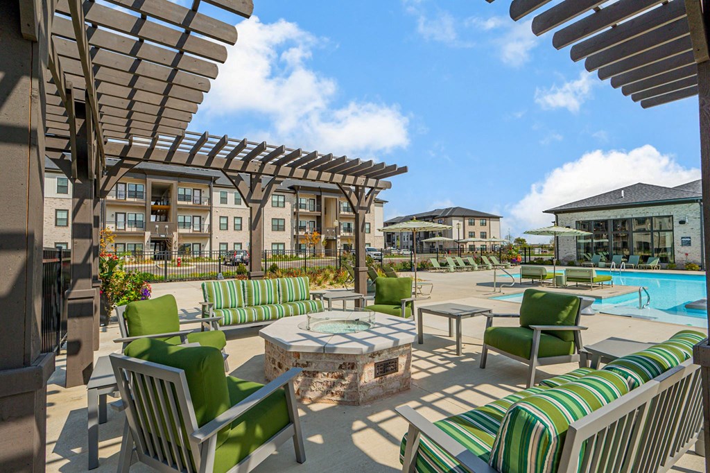 A sunny day at the poolside with green striped chairs and tables.