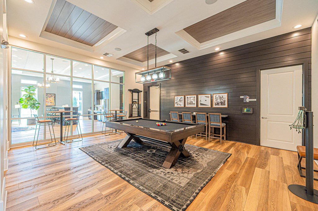 a game room with a pool table and a bar