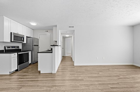 A kitchen with white cabinets and appliances.