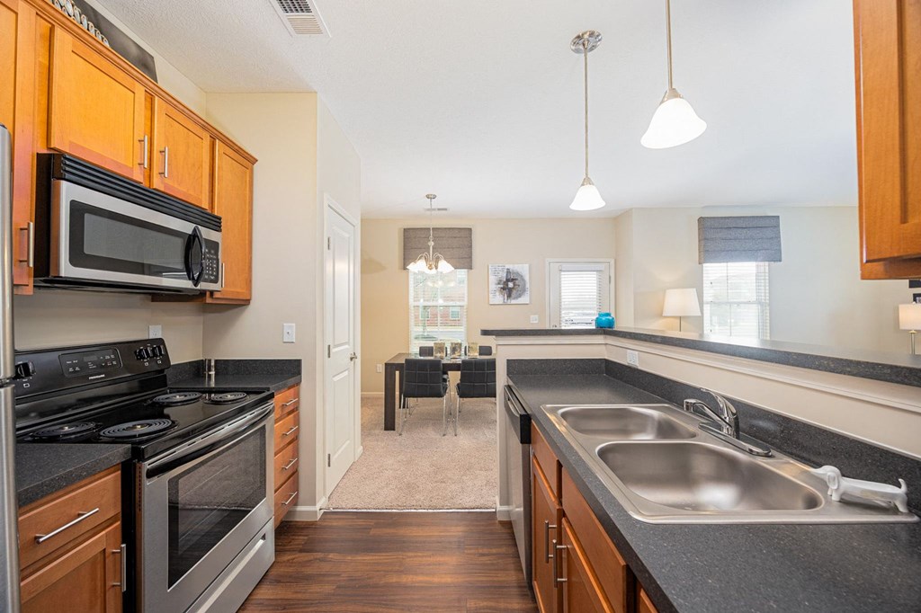A kitchen with wooden cabinets and black countertops.
