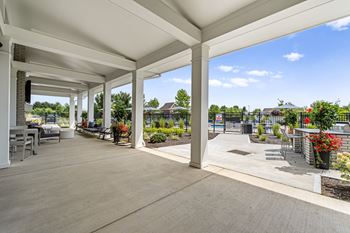 A covered patio area with a white ceiling and wooden floor.