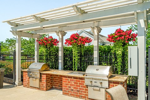 a patio with a barbecue grill and a pergola